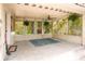 The screened-in patio, complete with a ceiling fan, curtains and rug offers an airy spot to relax and enjoy the outdoors at 316 29Th W St, Bradenton, FL 34205