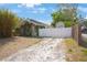 Exterior showcasing a gravel driveway leading to a house with overgrown vegetation, bamboo and a fenced backyard at 316 29Th W St, Bradenton, FL 34205