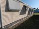 A close up side view of a beige mobile home with awning on a green lawn at 320 Tropic Dr, Osprey, FL 34229