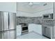 Modern kitchen with stainless steel appliances, granite countertops, and white cabinets at 340 Gulf Of Mexico Dr # 136, Longboat Key, FL 34228
