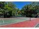 Well-maintained tennis court surrounded by mature trees, perfect for recreational play at 340 Gulf Of Mexico Dr # 136, Longboat Key, FL 34228