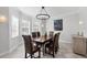 Dining room featuring a wood table, leather chairs, and a modern light fixture at 3905 Trentwood Pl, Sarasota, FL 34243