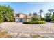 Circular driveway leading to a two-story home with a barrel tile roof and mature trees at 3905 Trentwood Pl, Sarasota, FL 34243