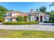 Inviting two-story home featuring a circular driveway, manicured hedges, and a barrel tile roof at 3905 Trentwood Pl, Sarasota, FL 34243