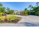 Elegant two-story home with a circular driveway, lush landscaping, and mature trees at 3905 Trentwood Pl, Sarasota, FL 34243