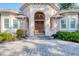 Front entrance features an arched portico, double wood doors and manicured landscaping at 3905 Trentwood Pl, Sarasota, FL 34243