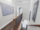 Hallway with dark hardwood floors, stairwell, and decorative wall art at 3905 Trentwood Pl, Sarasota, FL 34243
