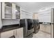 Well-equipped laundry room featuring front loading washer and dryer, granite countertop, and ample cabinet space for storage at 3905 Trentwood Pl, Sarasota, FL 34243