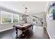 A living room with a pool table and a bright window view at 3905 Trentwood Pl, Sarasota, FL 34243