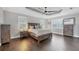 Comfortable main bedroom features hardwood floors, tray ceiling, fan, and matching and dressers and nightstands at 3905 Trentwood Pl, Sarasota, FL 34243