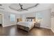 Comfortable main bedroom features hardwood floors, ceiling fan, and a large bed with three windows at 3905 Trentwood Pl, Sarasota, FL 34243