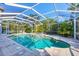Sparkling screened-in pool and spa surrounded by lush landscaping and a spacious deck for relaxation and enjoyment at 3905 Trentwood Pl, Sarasota, FL 34243