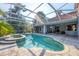 Captivating screened-in pool and spa seamlessly connected to an outdoor kitchen and living space for entertainment at 3905 Trentwood Pl, Sarasota, FL 34243