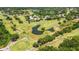 Scenic aerial view of a golf course with lush green fairways and water features, perfect for recreation at 4044 Penshurst Park, Sarasota, FL 34235