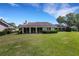 Beautiful backyard featuring a lush lawn and full view of the windows of the sunroom at 4044 Penshurst Park, Sarasota, FL 34235