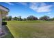 Expansive backyard featuring a lush green lawn and scenic views of mature trees, offering tranquil outdoor space at 4044 Penshurst Park, Sarasota, FL 34235