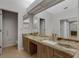 Bathroom featuring dual sinks with granite counters and a large mirror at 4044 Penshurst Park, Sarasota, FL 34235