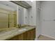 Bright bathroom with a granite countertop, cabinet, sink and large mirror and enclosed shower at 4044 Penshurst Park, Sarasota, FL 34235