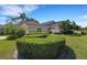 Landscaped home exterior featuring manicured hedges and vibrant greenery, enhancing the curb appeal at 4044 Penshurst Park, Sarasota, FL 34235