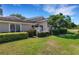Beautiful home exterior with manicured lawn, mature trees, and trimmed hedges creating a serene setting at 4044 Penshurst Park, Sarasota, FL 34235