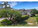 Charming exterior with lush landscaping, manicured hedges, and a well-maintained lawn, creating inviting curb appeal at 4044 Penshurst Park, Sarasota, FL 34235