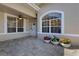 Charming front patio with decorative planters, brick pavers, and arched windows at 4044 Penshurst Park, Sarasota, FL 34235