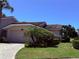 Charming one-story home with a paver driveway, a two-car garage, lush landscaping, and a beautiful tile roof at 4044 Penshurst Park, Sarasota, FL 34235