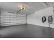 Spacious garage with a gray epoxy floor and white walls with lighting at 4044 Penshurst Park, Sarasota, FL 34235