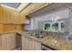 Kitchen featuring wooden cabinets, granite counters, stainless steel appliances and breakfast bar at 4044 Penshurst Park, Sarasota, FL 34235