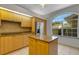 Kitchen with wooden cabinets, granite countertops, an island, and stainless refrigerator at 4044 Penshurst Park, Sarasota, FL 34235