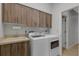 Convenient laundry room with washer, dryer, utility sink, and ample cabinet space for storage at 4044 Penshurst Park, Sarasota, FL 34235
