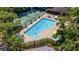 Community pool with a lap lane for exercise and tennis court in the background, and lounge chairs around the pool at 4044 Penshurst Park, Sarasota, FL 34235
