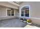 Inviting porch with gray brick pavers, neutral paint scheme, and flower pots adding colorful curb appeal at 4044 Penshurst Park, Sarasota, FL 34235