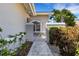 Paver walkway leads to gated courtyard entry with lush landscaping, enhancing the home's curb appeal at 4044 Penshurst Park, Sarasota, FL 34235