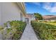 Paver walkway framed by manicured hedges and lush greenery, leading to a charming home entrance at 4044 Penshurst Park, Sarasota, FL 34235