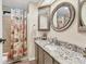Nicely updated bathroom with granite counters, a large mirror, and a shower with a coral themed curtain at 4312 14Th E St, Ellenton, FL 34222