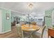 Open concept dining room, connecting living room and kitchen, features wood floors and seating for four at 4312 14Th E St, Ellenton, FL 34222
