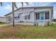 Single-story home with awning-covered windows, a turquoise front door, and cozy landscaping at 4312 14Th E St, Ellenton, FL 34222