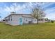 Exterior view of the home with a grassy yard and a blue door at 4312 14Th E St, Ellenton, FL 34222