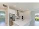 Bright, open kitchen with stainless steel refrigerator, white cabinets, and an island sink at 4324 Sea Marsh Pl, Parrish, FL 34219