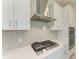 Modern kitchen with stainless steel range hood, cooktop, and subway tile backsplash at 4324 Sea Marsh Pl, Parrish, FL 34219