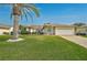 Charming home featuring a well-manicured lawn and a decorative palm tree in the front yard at 4360 Presidential Avenue E Cir, Bradenton, FL 34203