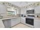 Bright kitchen featuring white cabinetry, countertops, and modern appliances with a tile floor at 4360 Presidential Avenue E Cir, Bradenton, FL 34203