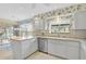 Bright kitchen features white cabinetry, neutral countertops, stainless steel appliances, and light-filled breakfast nook at 4360 Presidential Avenue E Cir, Bradenton, FL 34203