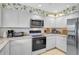 Well-lit kitchen featuring white cabinetry, countertops, and stainless-steel appliances at 4360 Presidential Avenue E Cir, Bradenton, FL 34203