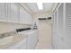 Laundry room with washer, dryer, utility sink, storage cabinets and closet at 4360 Presidential Avenue E Cir, Bradenton, FL 34203