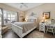 Bright bedroom with a white bed frame, light gray bedding, a ceiling fan, and a desk area at 4802 51St W St # 1908, Bradenton, FL 34210
