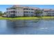 Scenic view of multi-story condos with screened patios overlooking a lily pad filled lake on a sunny day at 4802 51St W St # 1908, Bradenton, FL 34210