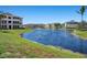 Community pond featuring beautiful landscaping and multiple residential buildings in the background at 4802 51St W St # 1908, Bradenton, FL 34210