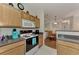 A view of the kitchen featuring light wood cabinets and a grey countertop at 4802 51St W St # 704, Bradenton, FL 34210